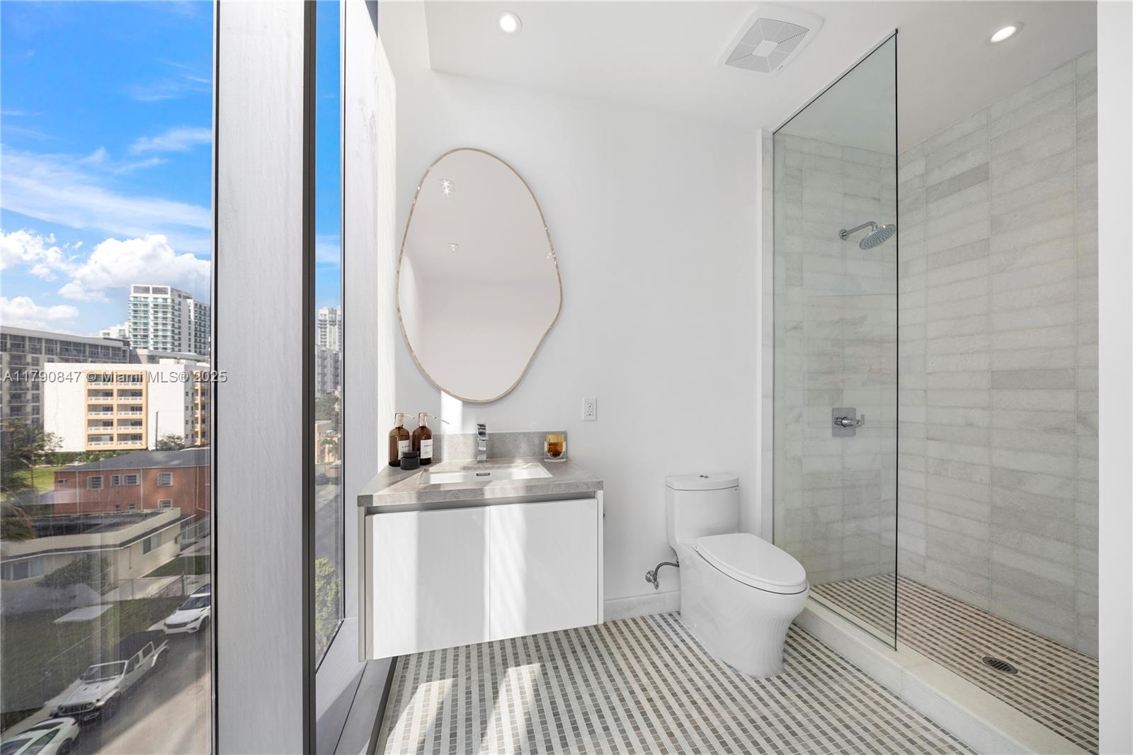 700 Northeast 26th Terrace, Unit TH403 Miami, FL 33137 - Photo 32 of 85 a bathroom with a sink a toilet and a mirror