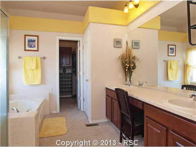 8072 Ferguson Road Peyton, CO 80831 - Photo 12 of 21 Master bath features Dual vanities, a dressing table, large soaking tub, free-standing shower and custom wardrobe closet system