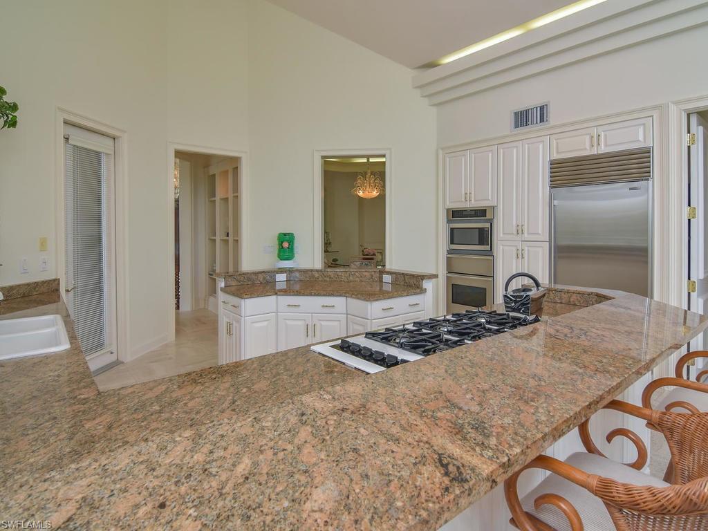 771 Brentwood Point Naples, FL 34110 - Photo 11 of 31 a kitchen with kitchen island granite countertop a stove and cabinets