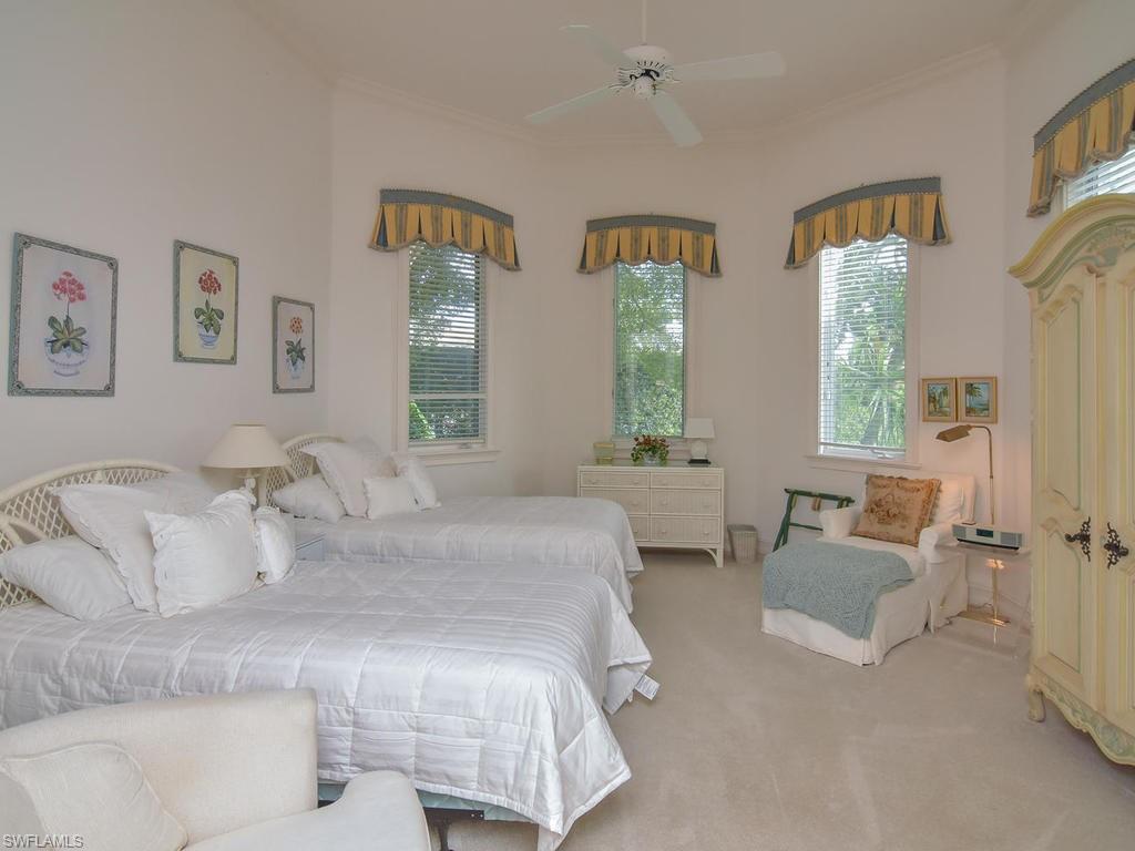 771 Brentwood Point Naples, FL 34110 - Photo 19 of 31 a large white bed sitting in a bedroom next to a window