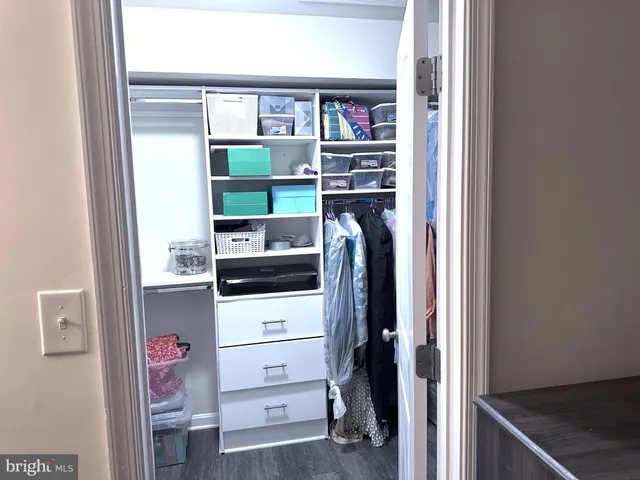 a view of walk in closet with clothes and shoes