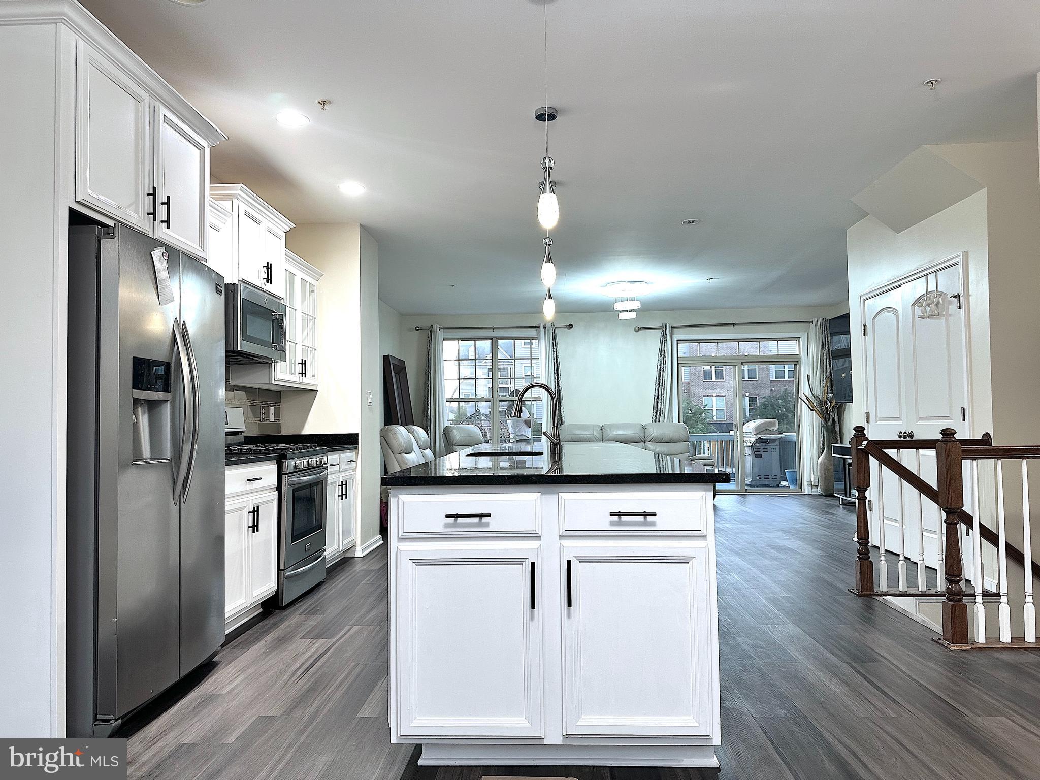 4718 Cambria Road Frederick, MD 21703 - Photo 2 of 32 a kitchen with stainless steel appliances kitchen island granite countertop a stove a sink a refrigerator and white cabinets with wooden floor