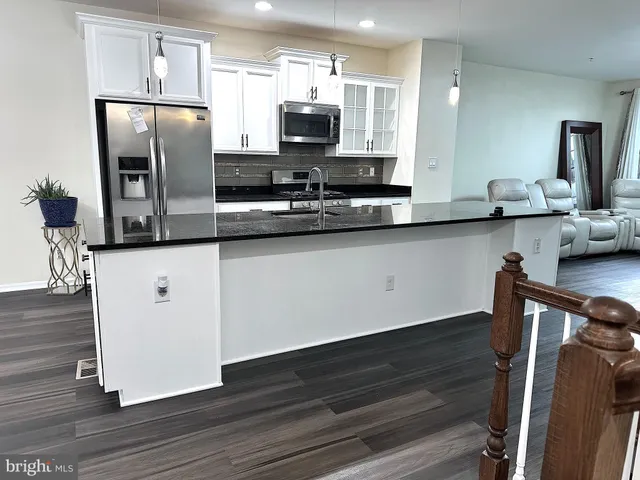 a kitchen with stainless steel appliances a microwave a sink and refrigerator