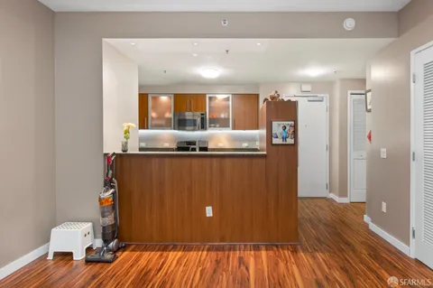 a kitchen with stainless steel appliances granite countertop a refrigerator and a wooden floor