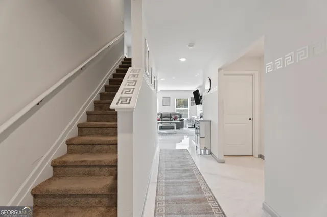 a view of a hallway with wooden floor and staircase