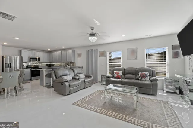 a living room with furniture a flat screen tv and a fireplace