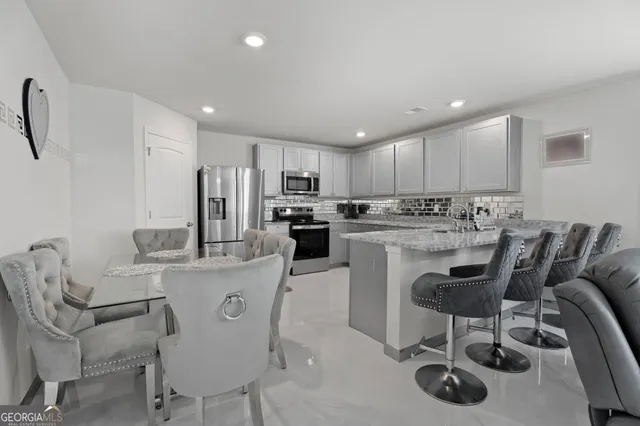 a kitchen with cabinets and chairs