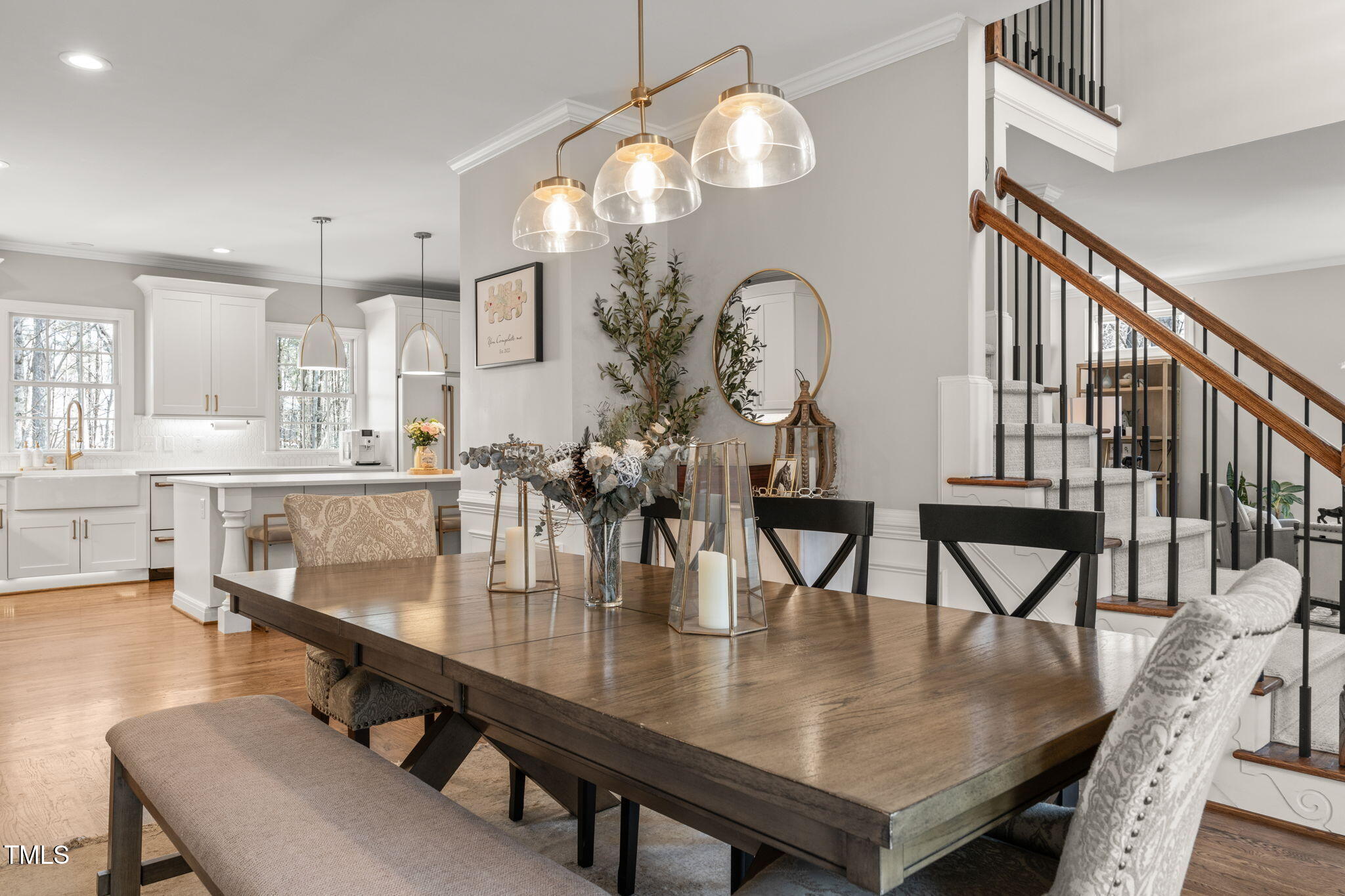 5032 Big Creek Road Raleigh, NC 27613 - Photo 5 of 46 a dining room with wooden floor a chandelier a wooden table and chairs