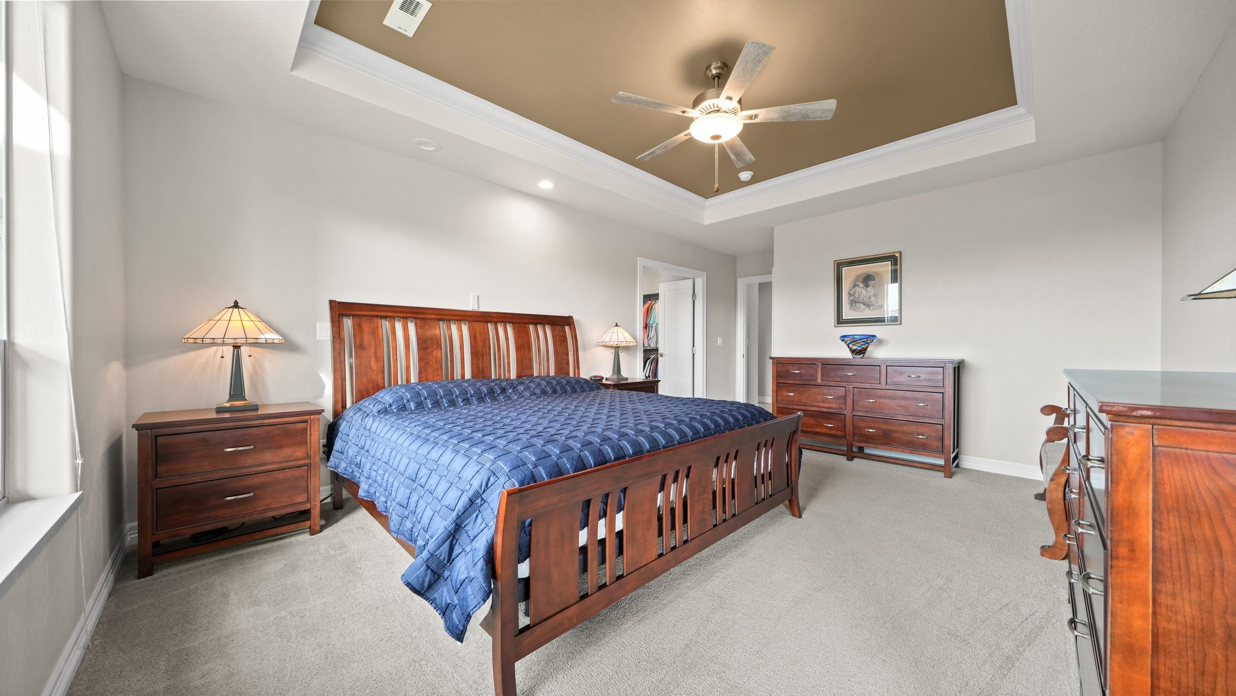 1295 Eagle Way Fruita, CO 81521 - Photo 12 of 36 a spacious bedroom with a bed and a chandelier