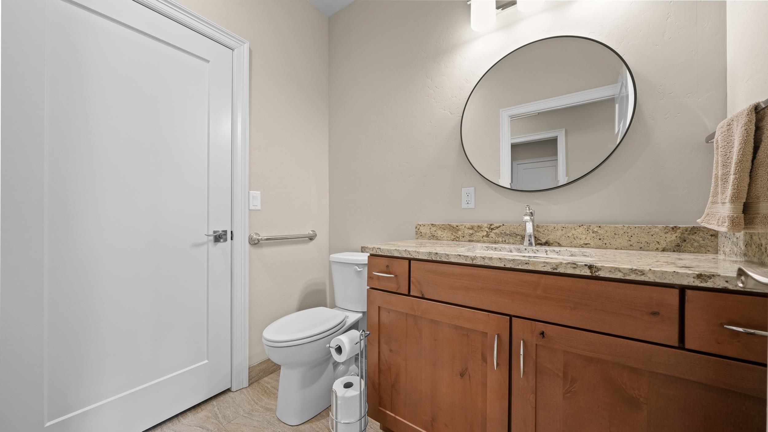1295 Eagle Way Fruita, CO 81521 - Photo 21 of 36 a bathroom with a granite countertop toilet a sink and a mirror