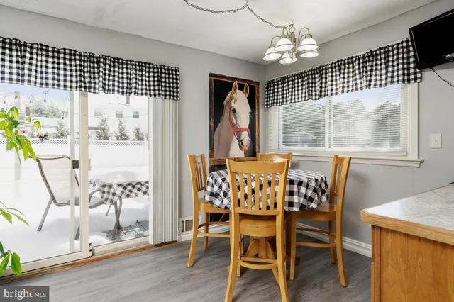 a dining room with furniture a chandelier and wooden floor