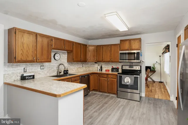 a kitchen with stainless steel appliances granite countertop a refrigerator stove and sink