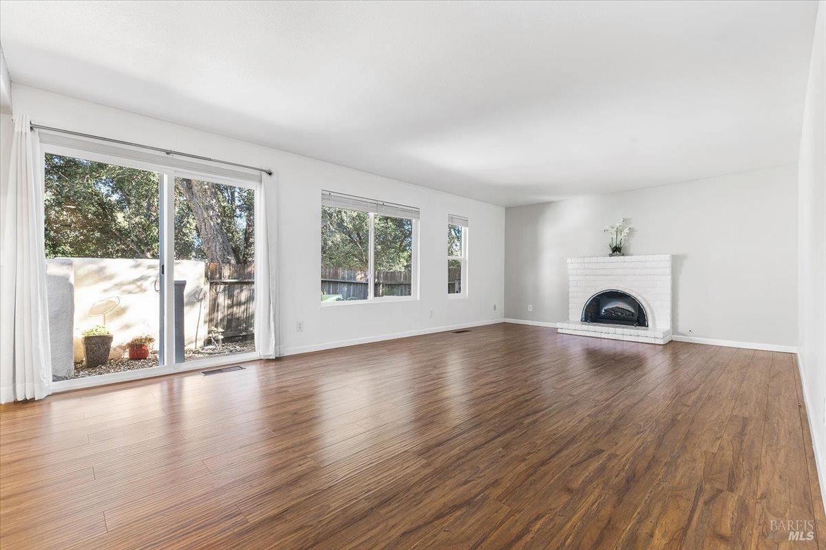 802 Adobe Drive Santa Rosa, CA 95404 - Photo 6 of 32 an empty room with wooden floor fireplace and windows