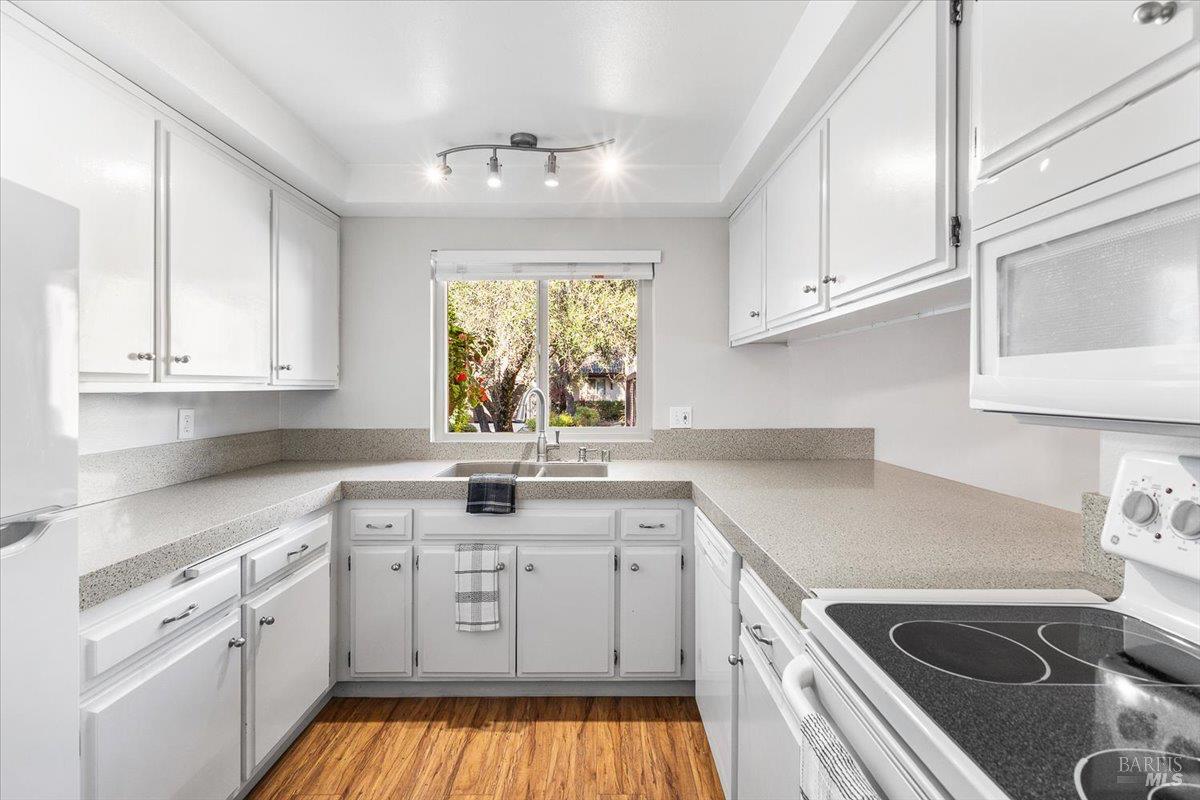 802 Adobe Drive Santa Rosa, CA 95404 - Photo 8 of 32 a kitchen with white cabinets appliances a sink and a window