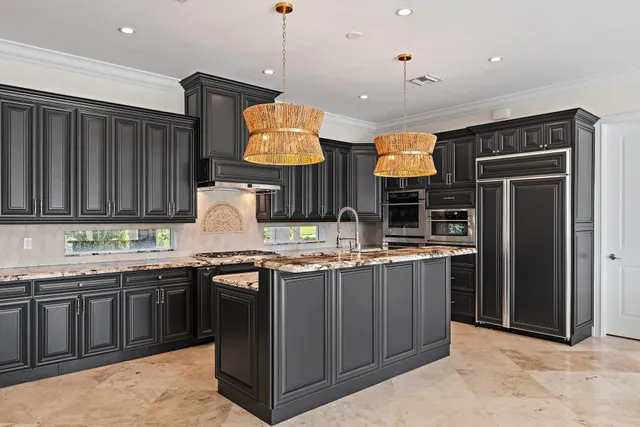 a bedroom with a bed a chandelier and a dresser