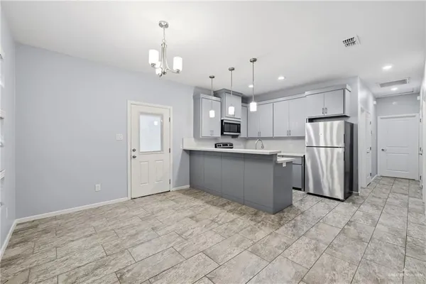 a kitchen with stainless steel appliances kitchen island granite countertop a refrigerator sink and cabinets
