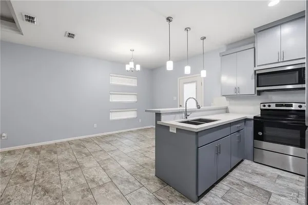 a kitchen with stainless steel appliances granite countertop a sink a stove and a wooden floors