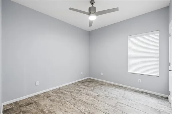 an empty room with a window and a fan