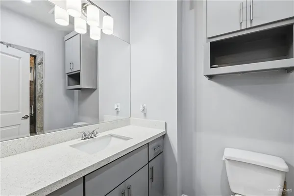 a bathroom with a sink a toilet and mirror