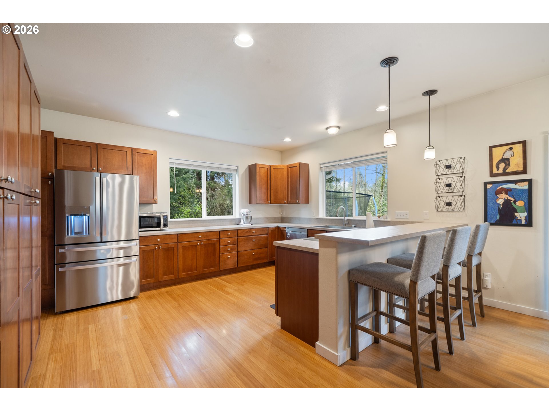 6040 Brickyard Road Tillamook, OR 97141 - Photo 11 of 41 a kitchen with stainless steel appliances kitchen island granite countertop a refrigerator a stove a sink a dining table and chairs with wooden floor