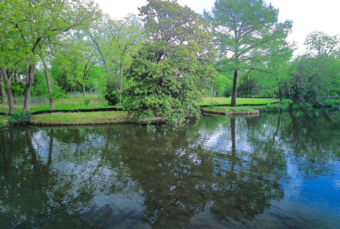 4703 Laguna Lane Austin, TX 78746 - Photo 23 of 32 a view of a lake view with a garden
