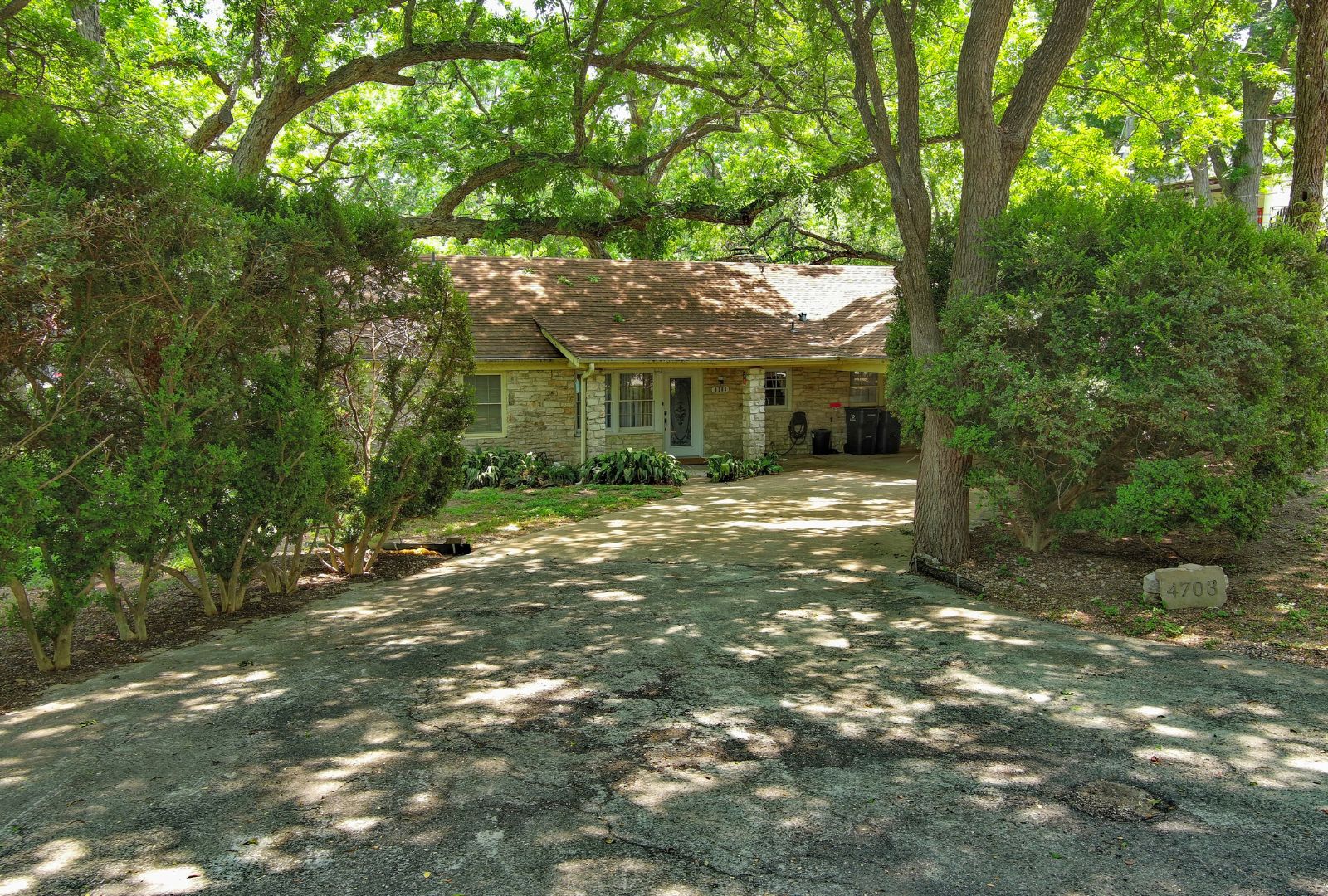 4703 Laguna Lane Austin, TX 78746 - Photo 9 of 32 a front view of a house with a garden
