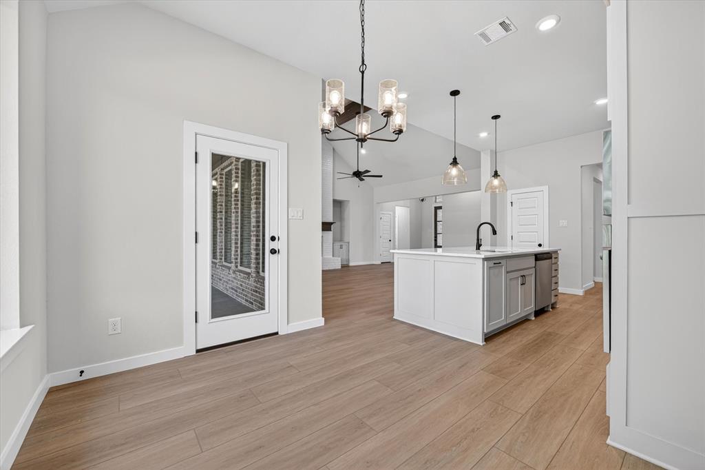 409 Mcalpine Springtown, TX 76082 - Photo 12 of 38 Spacious interior featuring wood-finish flooring and a central island with a sink