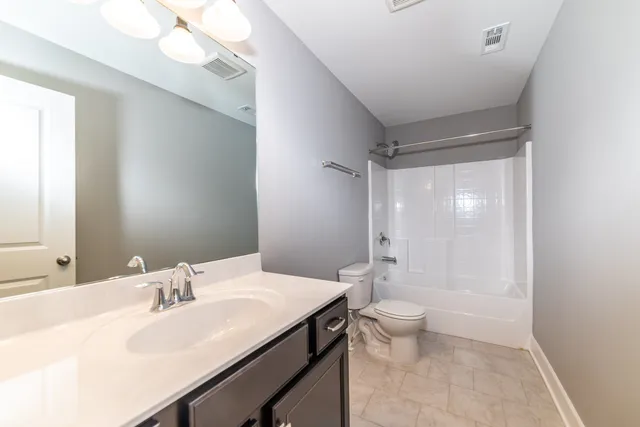 a bathroom with a sink a toilet a shower and a large mirror