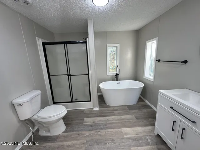 a spacious bathroom with a toilet a sink and a mirror