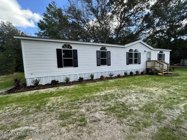 a front view of house with yard and green space