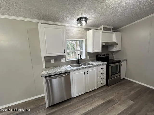 a kitchen with stainless steel appliances granite countertop a sink a stove a microwave a sink and cabinets