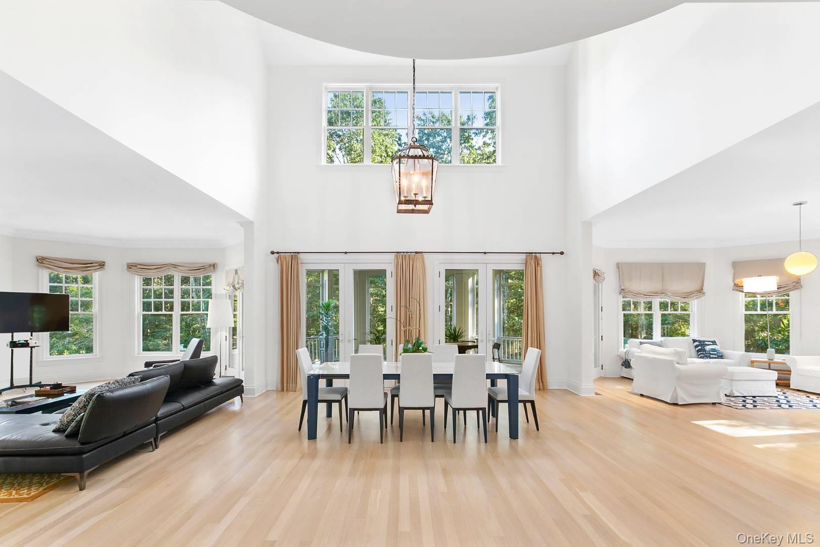 1477 Deerfield Road Water Mill, NY 11976 - Photo 2 of 17 Dining space featuring a high ceiling, a chandelier, and light wood-type flooring