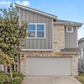a view of a house with large windows and a tree