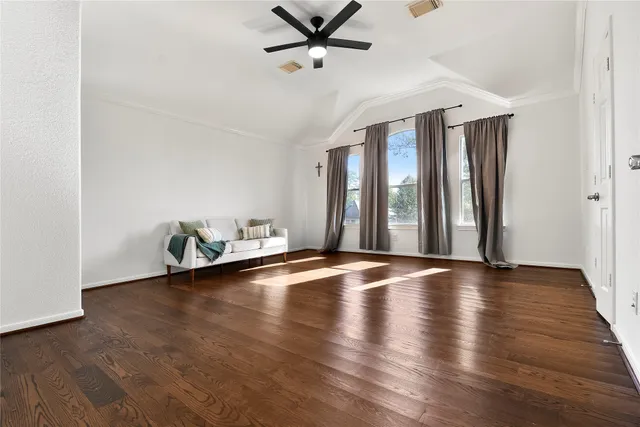 a view of an empty room with window and wooden floor