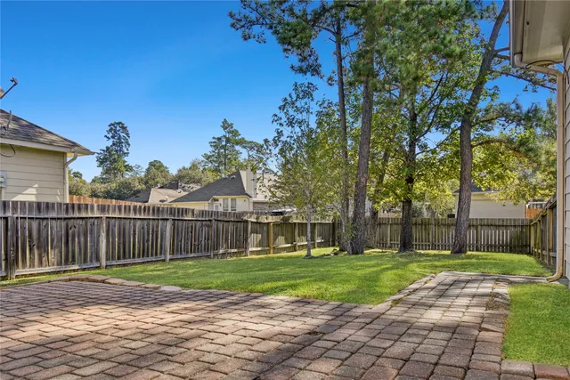 a view of a house with backyard and a tree