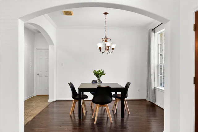 a view of a dining room with furniture wooden floor and a chandelier