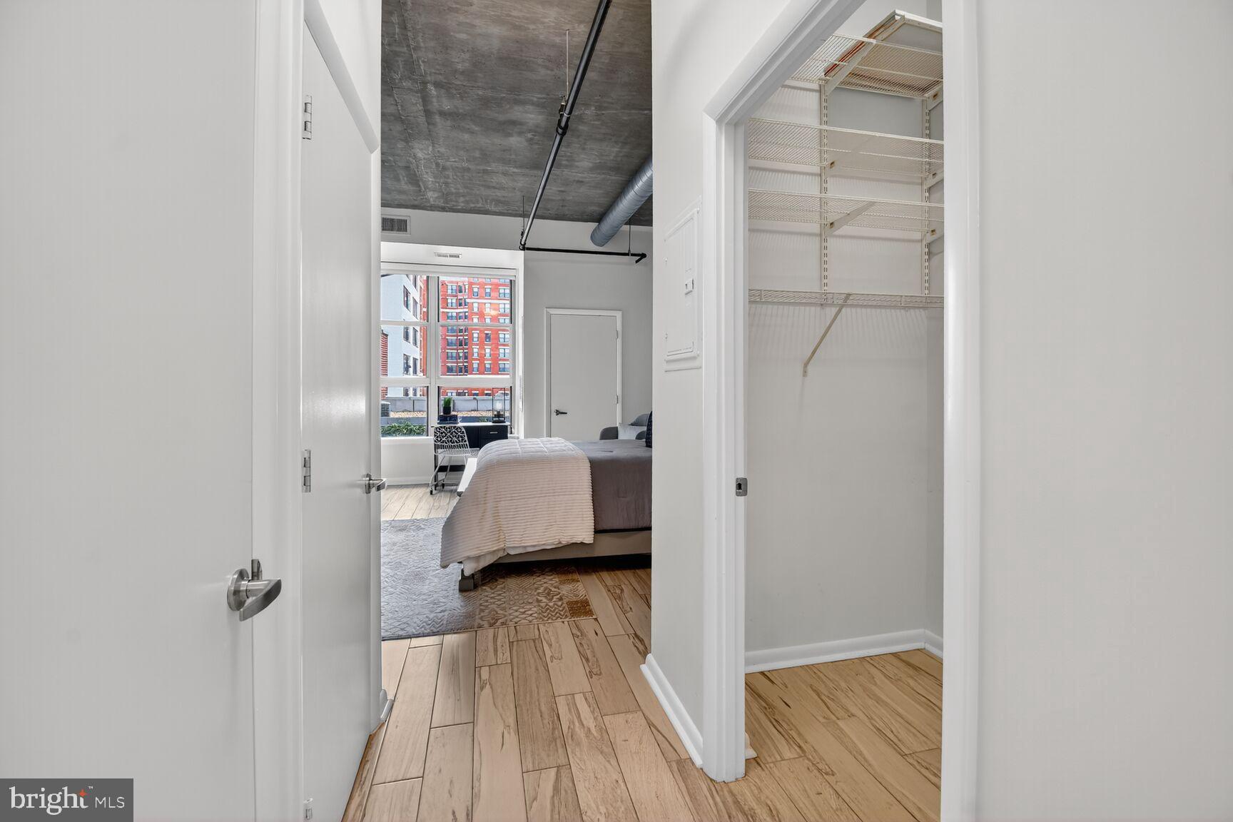 1300 N Street Northwest, Unit 214 Washington, DC 20005 - Photo 13 of 41 a view of a bedroom with a bed and wooden floor