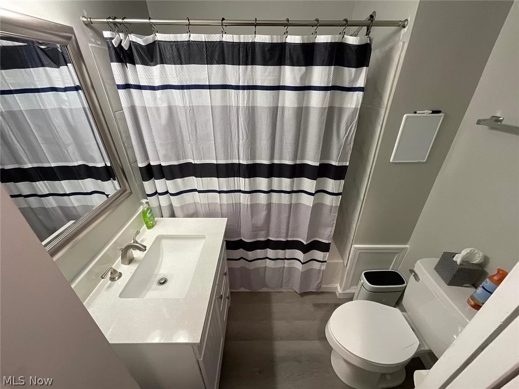 1850 Ronald Road Akron, OH 44312 - Photo 24 of 32 Full bathroom with shower / bathtub combination with curtain, toilet, vanity, and wood-type flooring