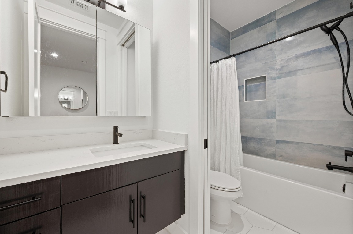 2104 East 2nd Street, Unit 1 Austin, TX 78702 - Photo 24 of 39 a bathroom with a bathtub shower sink vanity and toilet