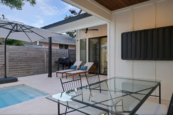 a view of a backyard with table and chairs under an umbrella
