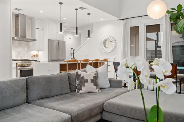 a living room with furniture chandelier and a large window