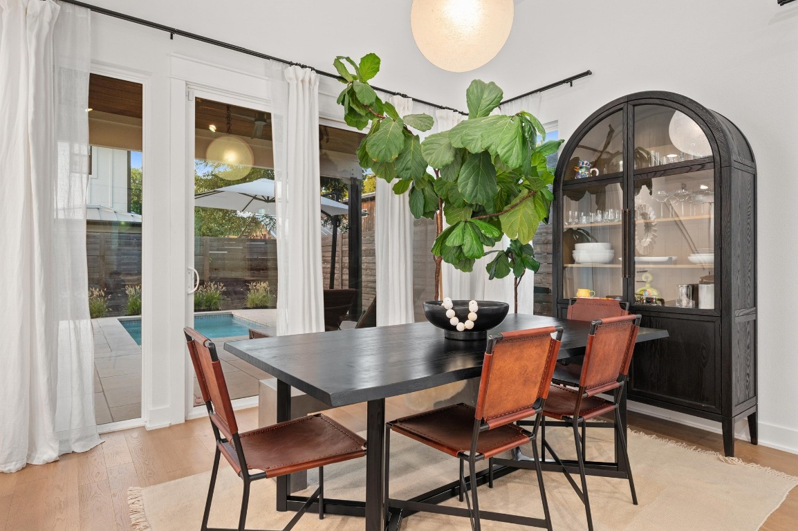 2104 East 2nd Street, Unit 1 Austin, TX 78702 - Photo 7 of 39 a dining room with furniture potted plants and a wooden floor