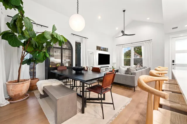 a dining room with furniture potted plants and a wooden floor