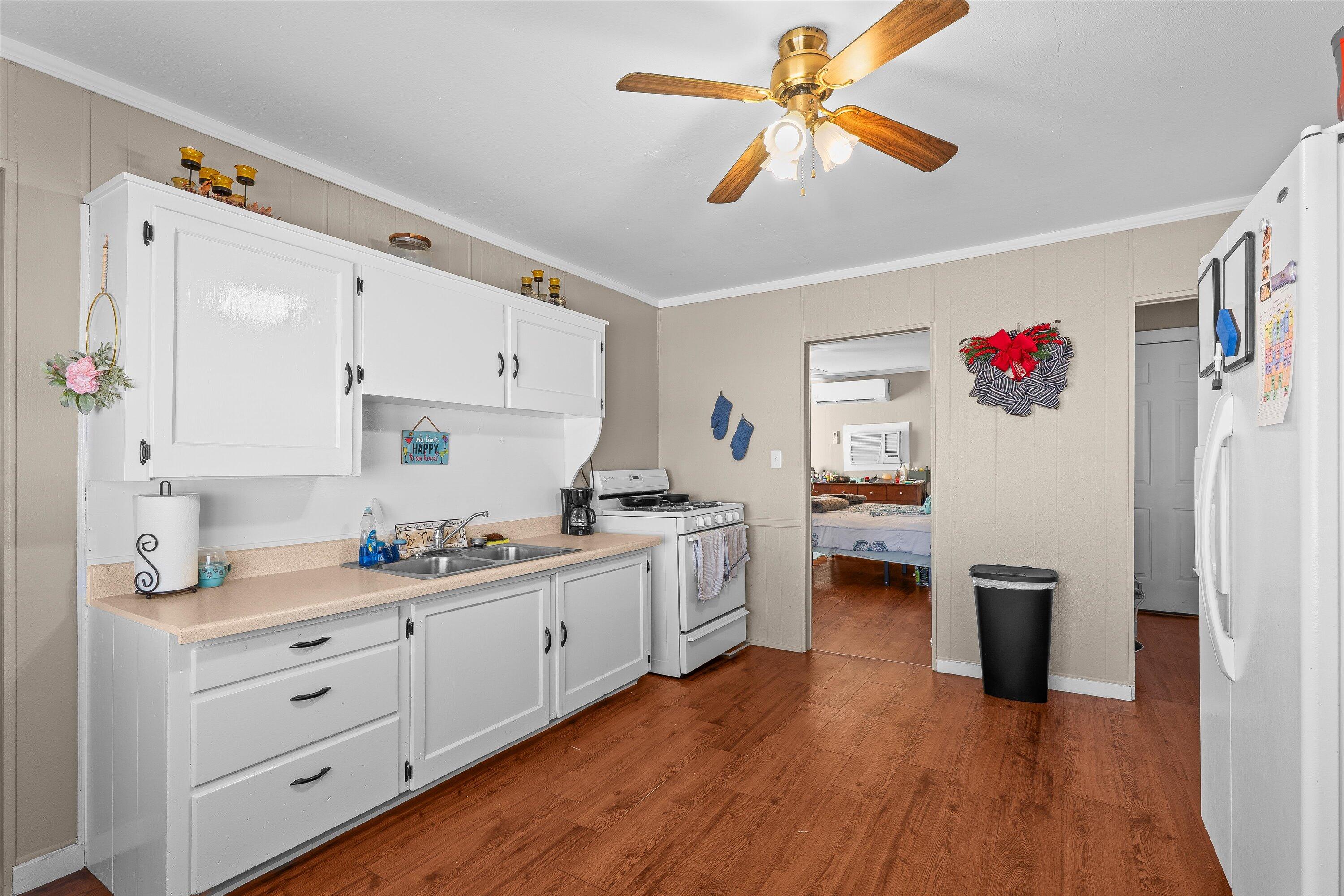 204 Austin Street Levelland, TX 79336 - Photo 7 of 13 a kitchen with white cabinets and white appliances