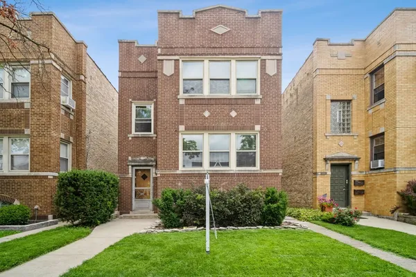 front view of a brick house with a yard