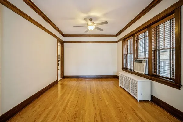 a view of an empty room with a window and wooden floor