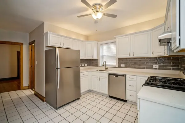 a kitchen with a refrigerator sink and cabinets