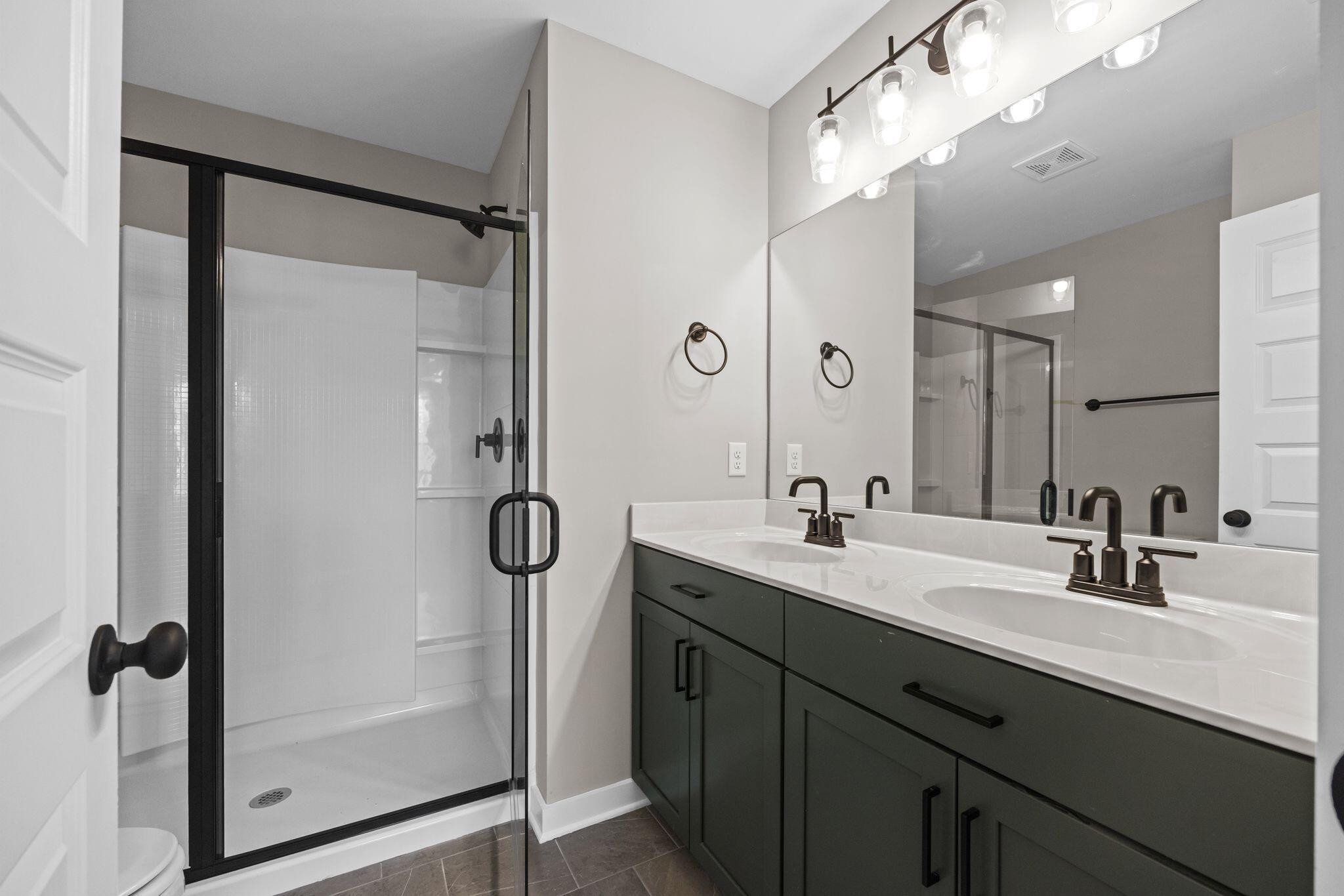 2413 East 17th Street Chattanooga, TN 37404 - Photo 16 of 42 a bathroom with a double vanity sink mirror and shower