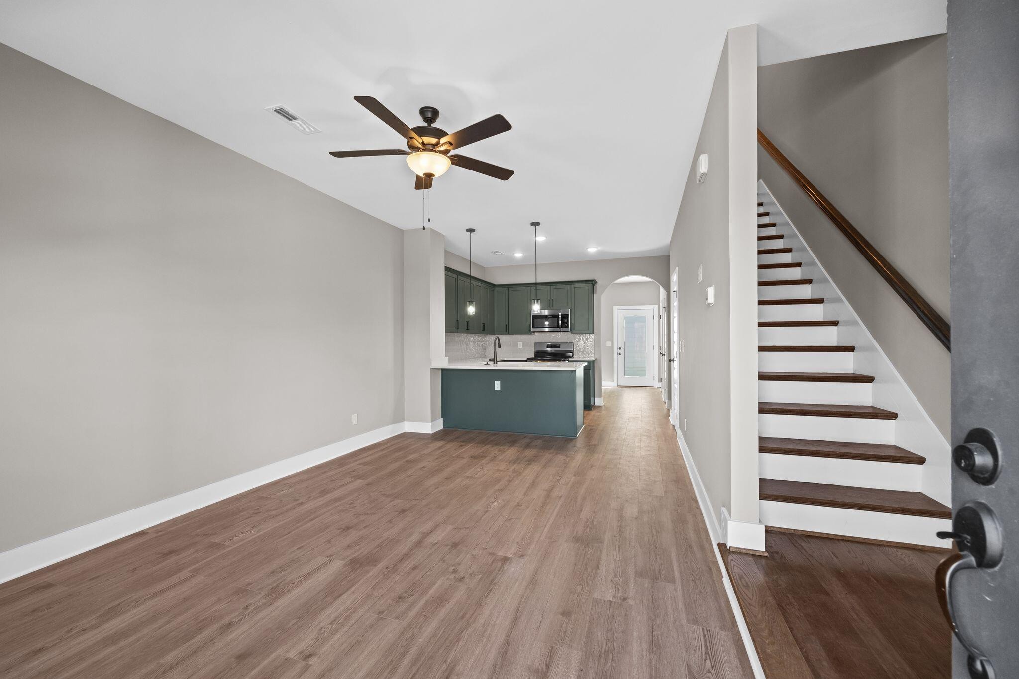2413 East 17th Street Chattanooga, TN 37404 - Photo 8 of 42 a view of a kitchen with wooden floor electronic appliances and stairs