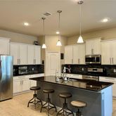 a kitchen with granite countertop a sink a counter space appliances and cabinets